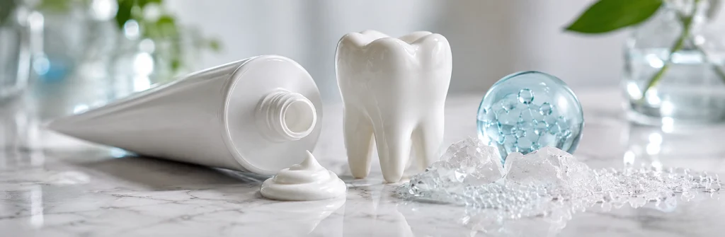 Fluoride-free toothpaste with hydroxyapatite shown with a toothpaste tube, tooth model and mineral crystals on a clean bathroom counter