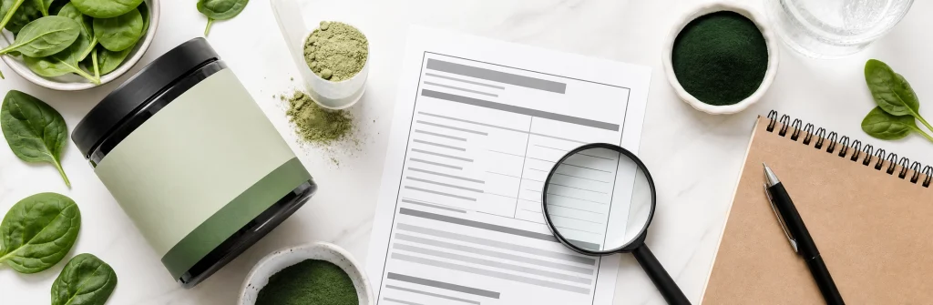 Magnifying glass over a greens powder label with spirulina, chlorella, and ingredient notes